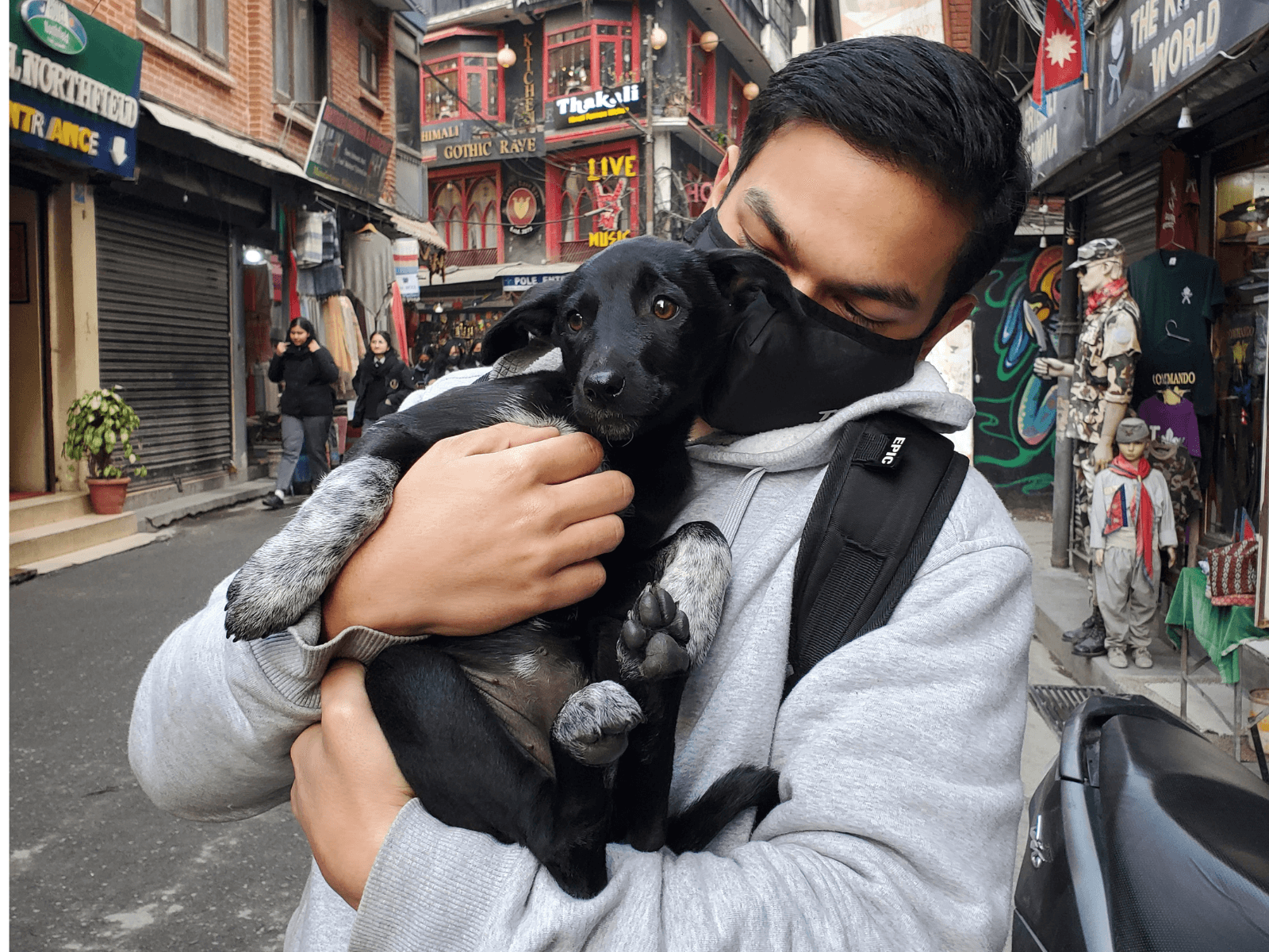 A rescued puppy being held by a new companion in Kathmandu